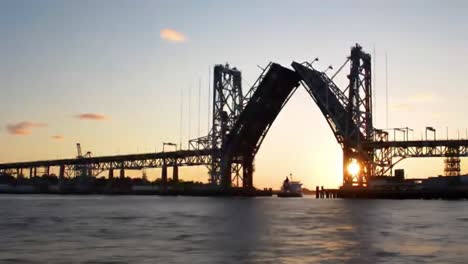 witness the majestic opening of the bridge as the sun sets, creating a beautiful silhouette against the water. this moment captures the essence of engineering and nature combined.