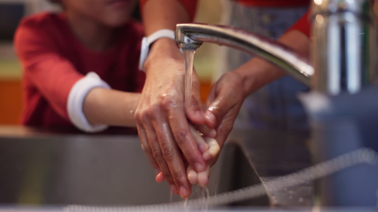 Child and adult washing hands