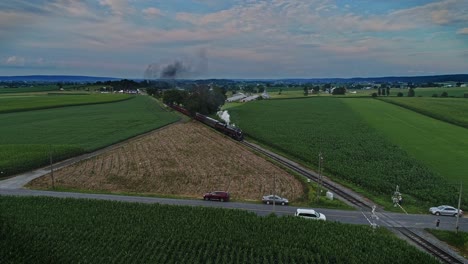 una vista aérea de un antiguo tren de pasajeros de vapor que sopla humo a través de las tierras agrícolas de pensilvania
