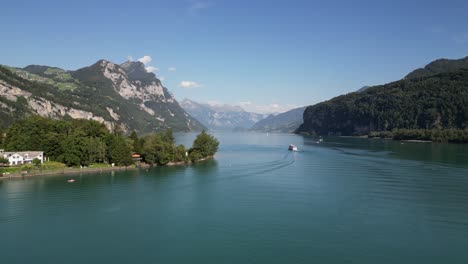 following a boat that is in the centre of a river heading towards great mountains in the background of the horizon into the far away never ending story clear day adventure holiday destination cinema