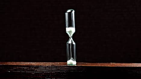 sand clock on wooden background. hourglass as time passing concept.