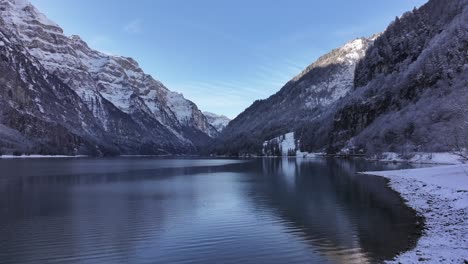 klöntalersee serenity: a breathtaking winter scene on lake klöntalersee in klöntal, switzerland. snow-capped mountains rise majestically above the tranquil waters.