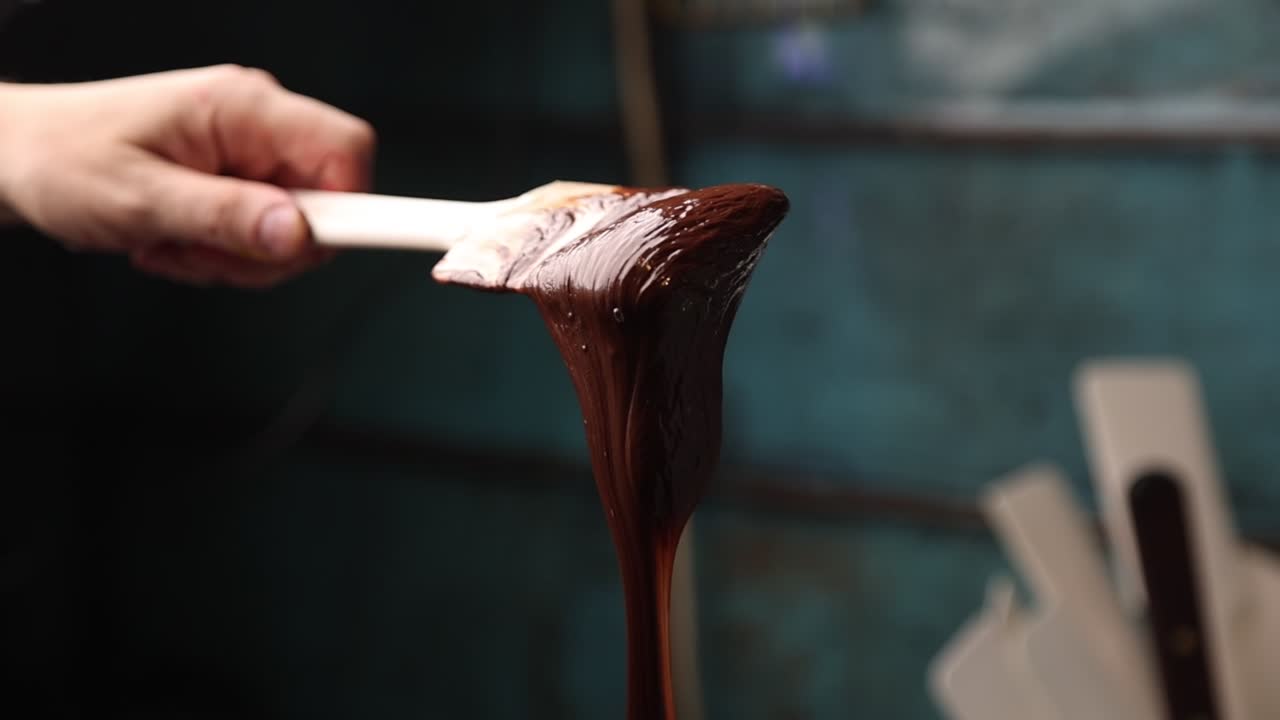 Primo piano di cioccolato fuso che cola da una spatola