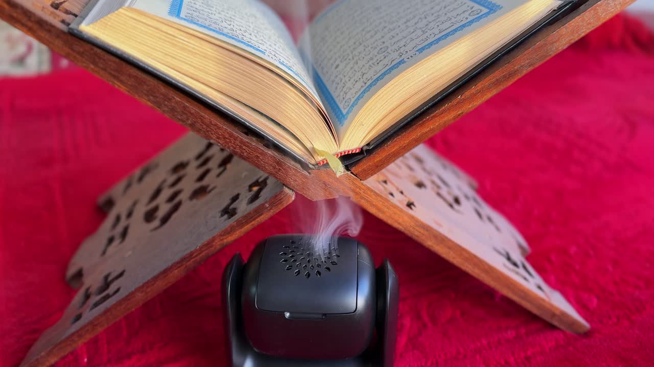 4K footage of the Quran on a traditional wooden rehal with incense smoke rising, creating a serene spiritual atmosphere. Ideal for Ramadan, prayer themes, or religious content.