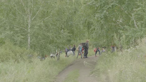 people walking through a forest path