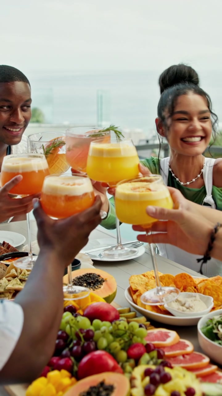 Grupo diverso de amigos brindando con cócteles en un brunch al aire libre