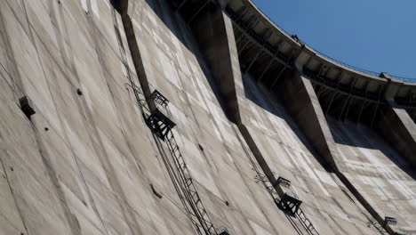 large concrete dam wall with maintenance ladders