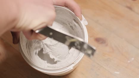 a worker mixes the material for puttying the walls