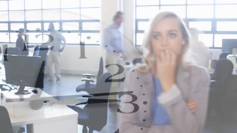 Woman-working-in-an-office-and-clock-in-the-foreground