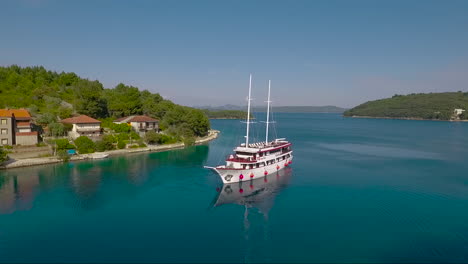 Antena-Alrededor-De-Un-Velero-Y-Un-Pequeño-Pueblo-En-Croacia