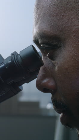 scientist using a microscope