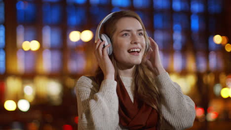 Smiling-girl-listening-music-headphones-outdoor.-Happy-woman-having-fun-outside