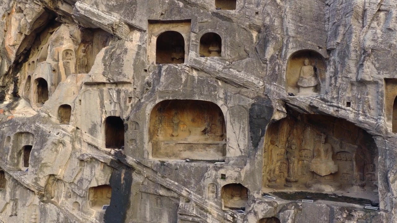 Gigantesco Buddha Vairocana scolpito nella scogliera della dinastia Tang, Grotte di Longmen, arte buddista cinese millenaria.