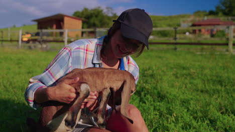 woman and baby goat on farm