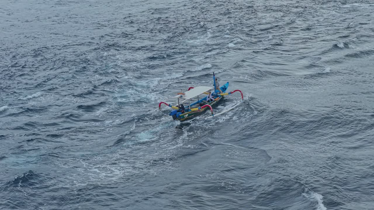 Traditional balinese jukung fishing boat sailing on the ocean