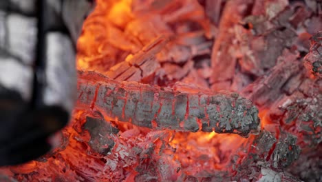 glowing embers in hot red color - hot embers of burning wood - close up shot