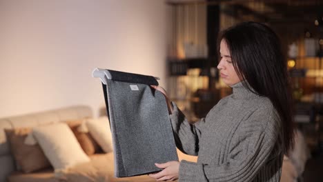 a beautiful longhaired brunette examines a catalog of furniture fabrics in a furniture salon a beautiful longhaired brunette carefully examines a catalog of furniture fabrics in a furniture salon selection of furniture for a new house in a modern furniture salon