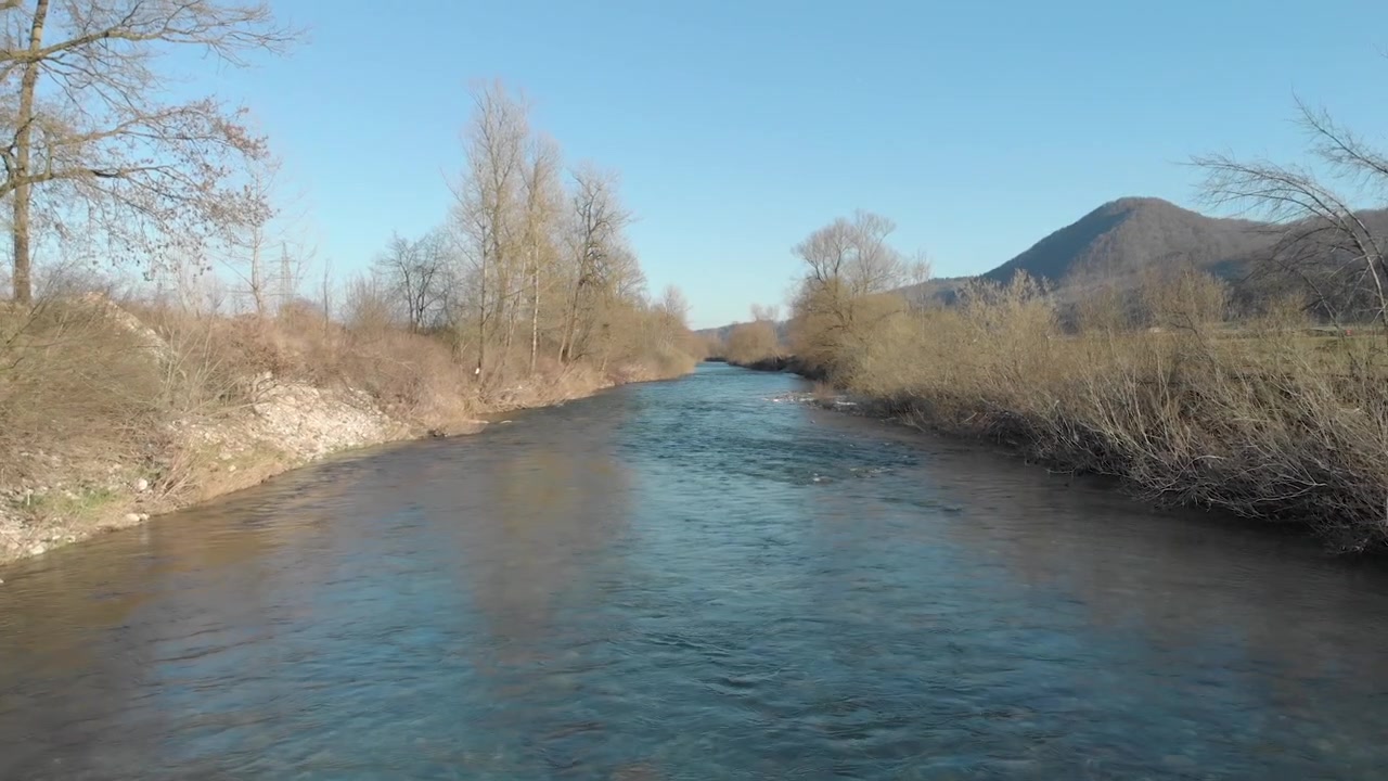 Huzurlu bir arka planla yavaş akan nehir suyunun üzerinde uçan drone