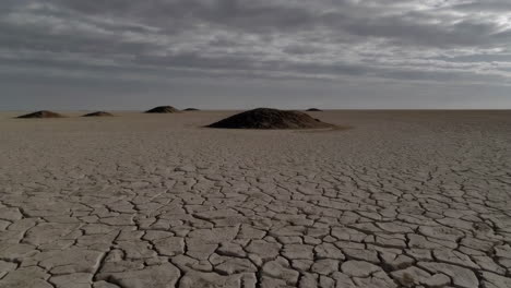dried, cracked earth landscape with small mounds