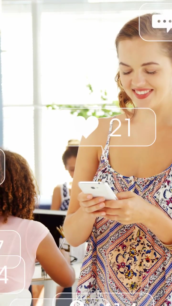 Vertical video: Woman tapping phone in office causing animated social media icons and rising likes