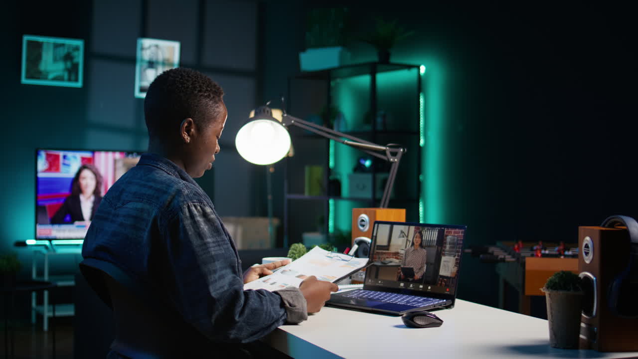 Woman working from home at night on a laptop