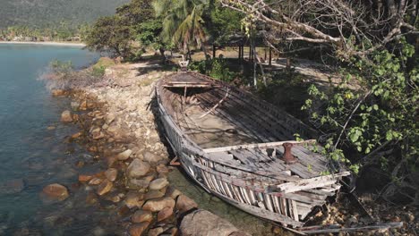 Luftaufnahme,-Verwöhntes-Holzboot-Am-Ufer-Des-Meeres