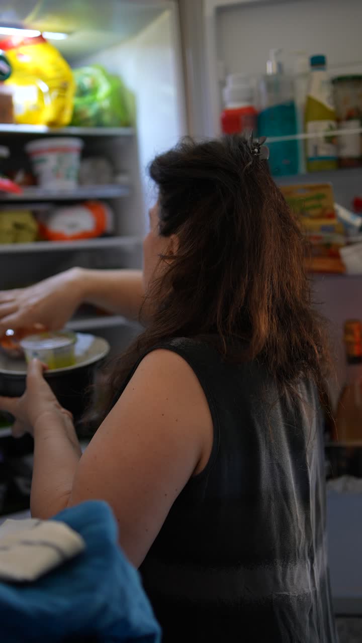 mujer organizando comida en un refrigerador