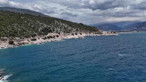 -Drohnenansicht,-Während-Klares-Wasser-Zwischen-Steinen-Fließt-Und-Schaum-Erzeugt,-Fließendes-Wasser-Trifft-Auf-Die-Steine-Und-Erzeugt-Schaum