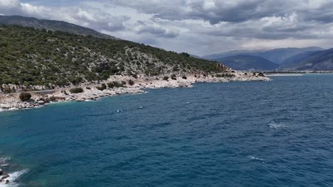 drone vista volando como el agua clara fluye entre las piedras creando espumas, el agua que fluye golpea las piedras formando espumas