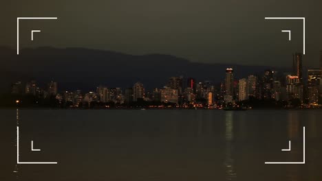 interfaz de cámara digital contra la vista del mar y el paisaje urbano por la noche