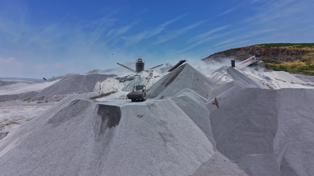 Construction site with heavy machinery moving gravel and sand