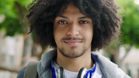 Trendy-Afro-American-man-smiling-outdoors-against