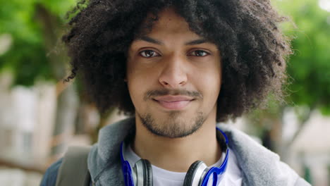 trendy afro american man smiling outdoors against