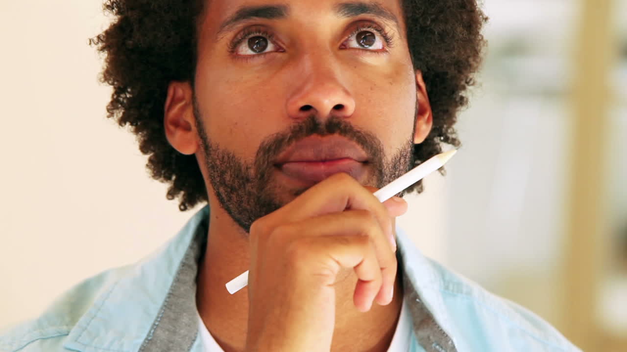 hombre de negocios casual pensando y sosteniendo la pluma