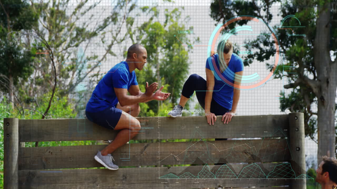 Two people in blue sportswear climbing over wooden fence with data overlay animation