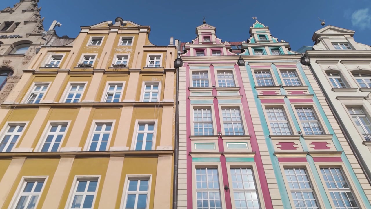 Edifícios charmosos na Praça do Mercado de Wroclaw, fachadas coloridas com charme histórico e atmosfera de praça animada.