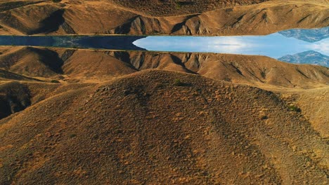 aerial view of a valley with a lake reflection