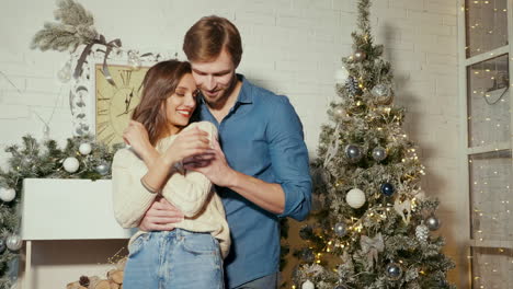 couple hugging by christmas tree