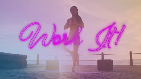 neon púrpura trabajo de texto pancarta contra afroamericano mujer en forma realizando yoga en el paseo marítimo
