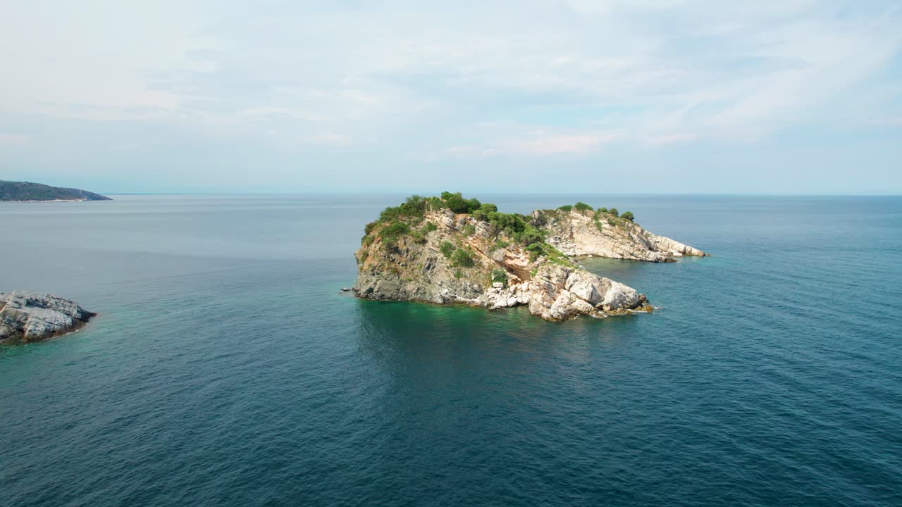 vista de órbita aérea circular de la isla de gramvousa con una iglesia blanca, rodeada por el mar mediterráneo, pájaros volando, altos picos de montaña, vegetación verde, thassos, grecia