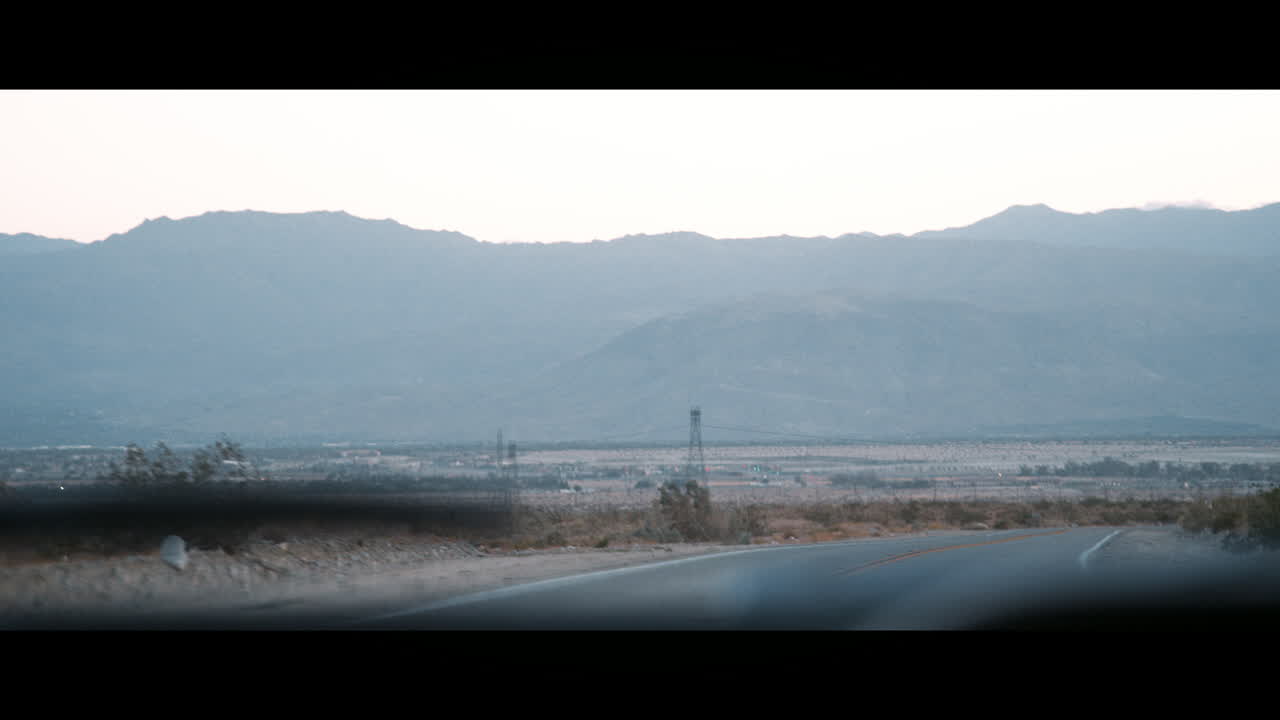 도로와 지평선은 움직이는 자동차 앞 유리창을 통해 볼 수 있습니다.