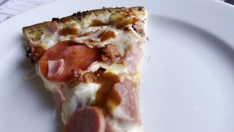 a close-up of a single slice of pepperoni pizza resting on a plate, showcasing its crispy crust, melted cheese, and savory toppings, tempting and perfect for pizza lovers.