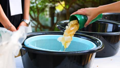 people sorting waste into recycling bins