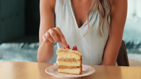 mujer sonriente comiendo una cereza de la pastelería