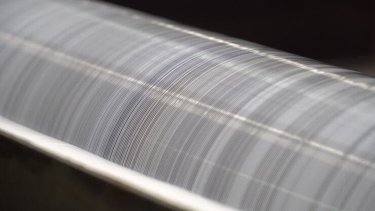 Rulli rotanti ricoperti di colla vinilica bianca.