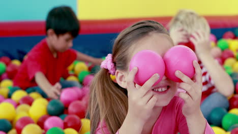 cute children playing and having fun in the ball pool