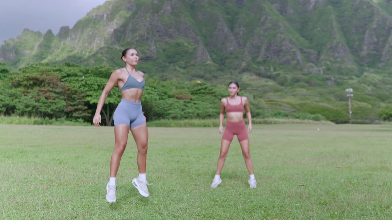 Two fitness models doing jump squats