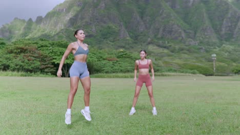 two fitness models doing jump squats