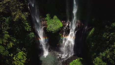 going down aerial view on the air terjun fiji waterfalls with rainbow reflection in middle of rain forest, one of the most famous popular and beautiful destinations while travel to bali, indonesia