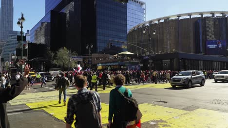 people crowd the streets near madison square garden in new york, their voices rising in support of trump as the city glows in the afternoon sunlight